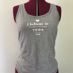 grey tank top Grey tank top with the words "I believe in trauma-informed yoga" on it